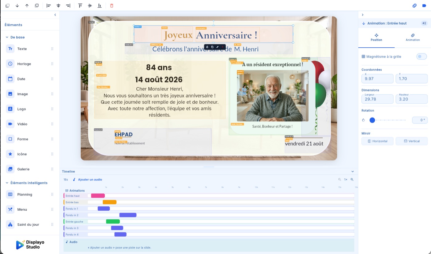 Le Studio Displayo : panneau d'éléments à gauche, slide d'anniversaire en cours d'édition au centre, réglages à droite, timeline en bas